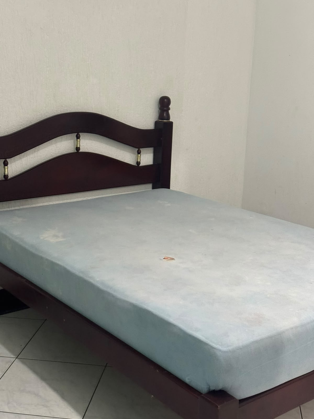 Dormitório com cama de madeira e cabeceira curva, colchão claro e piso de azulejo